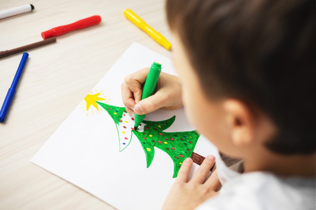 niño pintando dibujo árbol navidad